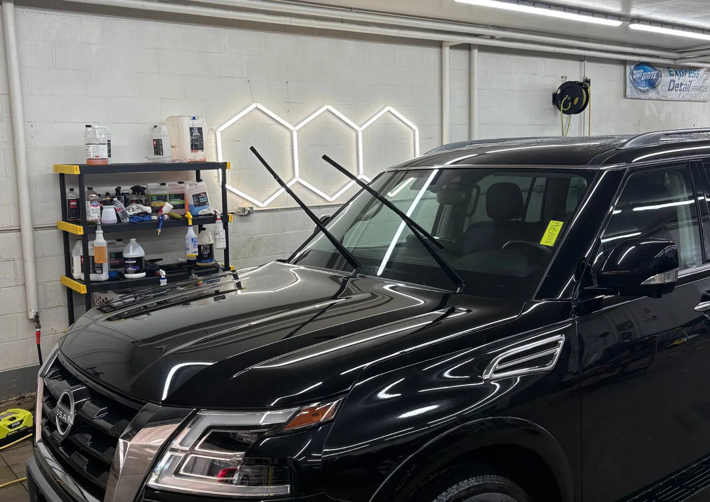 Exterior detail — black Nissan Armada hood showing clean, swirl-free reflections — Westerville, Ohio | Touch It Up Automotive