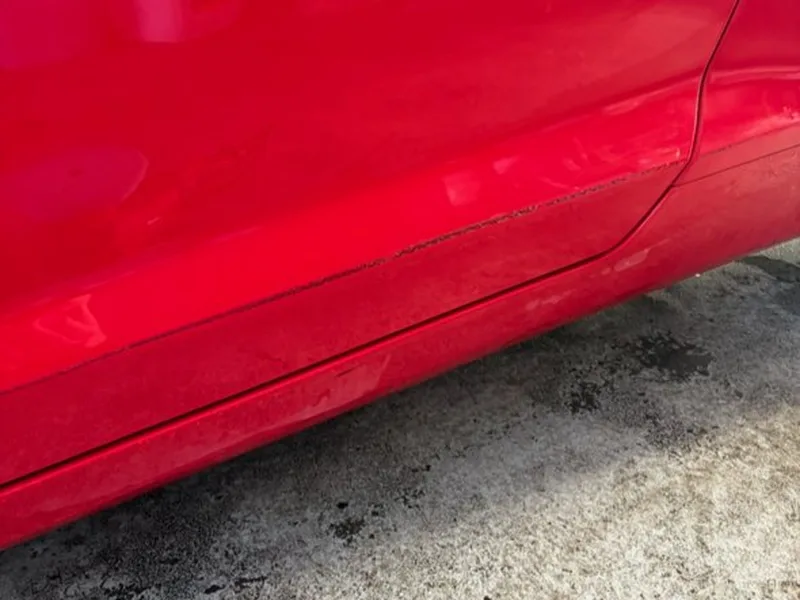 Paint touch up before — scratched red door panel — Westerville, Ohio | Touch It Up Automotive